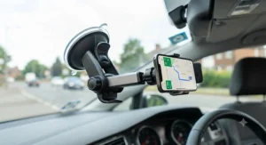 An adjustable windscreen phone mount positioned for hands-free satellite navigation in a car.