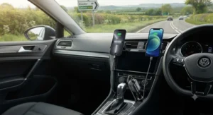 Dual-port USB-C car charger plugged in, powering two iPhones simultaneously on a road trip across the UK.