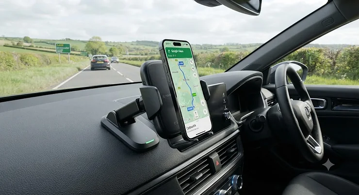 Fast wireless charging car mount securely installed on a vehicle dashboard, showing a smartphone charging wirelessly on a British road.