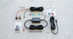An overhead view of a universal hardwire kit for dash cam featuring all included components, wiring, and fuse taps.