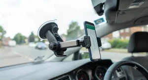 Universal windscreen phone mount compatible with various smartphones inside a vehicle.