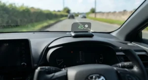 A compact HUD speed display projector mounted on a car dashboard console