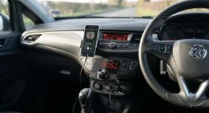 A digital display on a wireless Bluetooth FM transmitter tuned to a static FM frequency to stream music to the car radio.