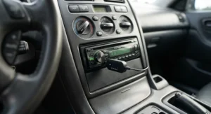 A compact wireless bluetooth receiver connected directly to an older car stereo aux input.