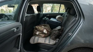 A traveler packing a memory foam car seat cushion for a cross-country road trip
