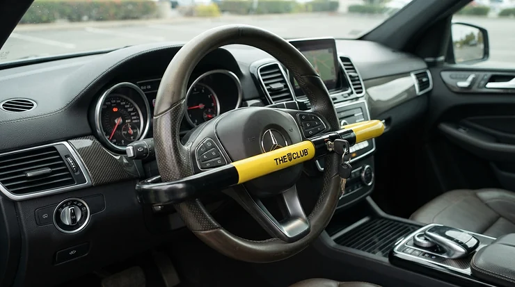 Robust steering wheel locks under £30 fitted across a large leather steering wheel inside a family SUV.